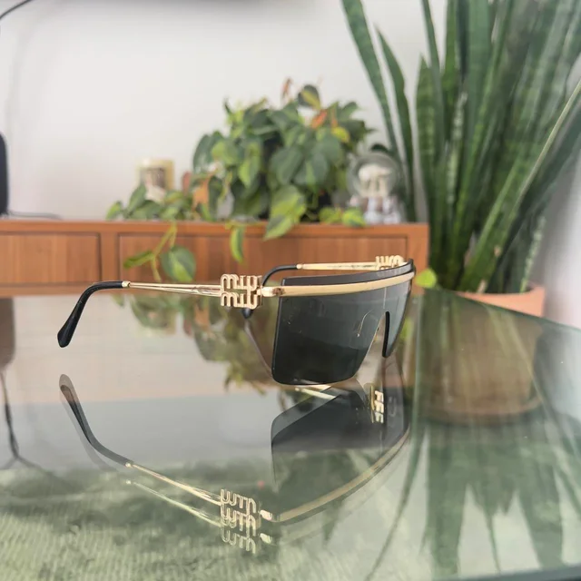 Miu Miu Women's Oversized Sunglasses - Black/Gold in gold|black from Depop, photo 2 of 6